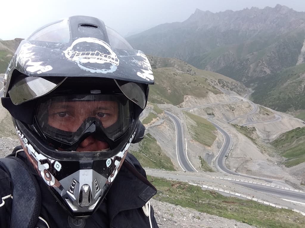 Motorcyclist riding a blue bike in the Pamir