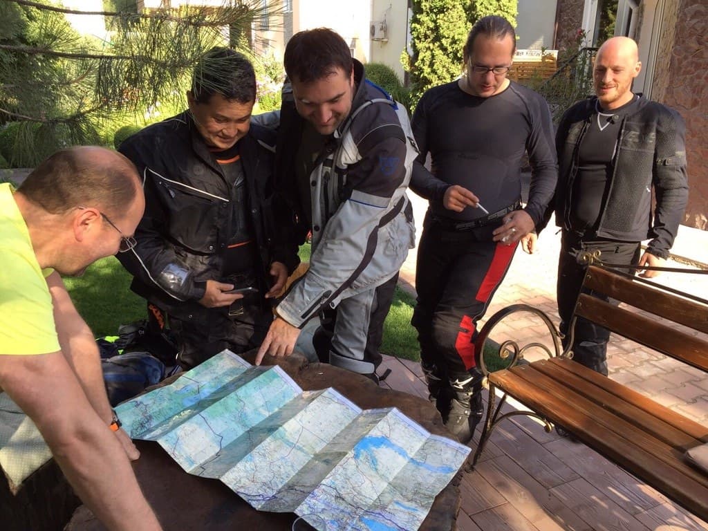 Riders planning the Pamir route on a paper map