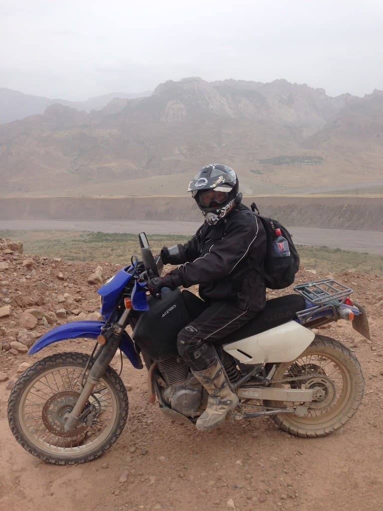Motorcyclist on a blue bike above the valley
