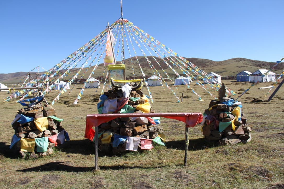 Prayer flags stretched across an open highland landscape
